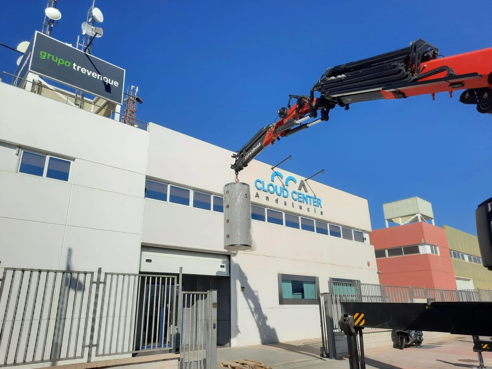 Grúa colocando equipos de climatización en la cubierta del centro de datos Cloud Center Andalucía en Granada.
